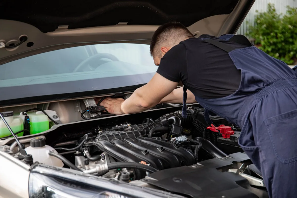 Mécanicien intervenant sur un moteur automobile